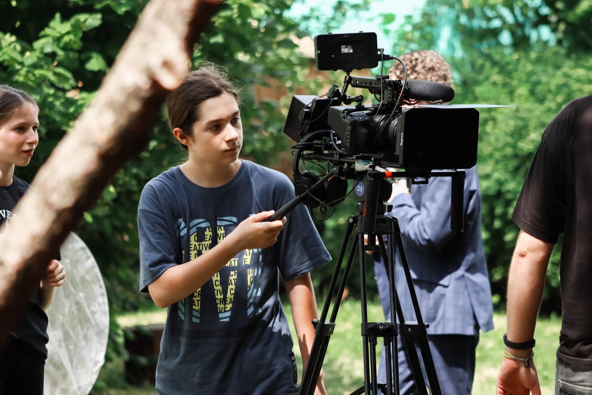 Účastník filmové školy obsluhuje profesionální kameru při natáčení